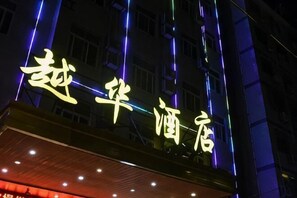 A building with illuminated signage in a foreign script, likely indicating a hotel or similar establishment. - Xianyou Yue Hua Hotel (Xianyou)