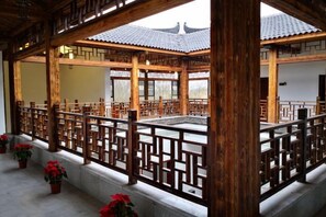 A traditional wooden pavilion with a tiled roof, surrounded by a wooden fence, and potted plants. - Huaqitang Rural Life Hostel (Wuhan)