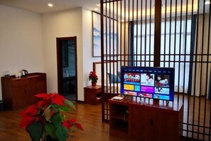 A room with a wooden TV stand, a potted plant, and a sliding door. - Huaqitang Rural Life Hostel (Wuhan)