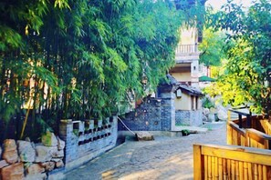 A narrow cobblestone street flanked by traditional buildings with stone walls and wooden fences. - Huaqitang Rural Life Hostel (Wuhan)