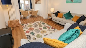 Una sala de estar con un sofá, una mesa de centro y un comedor con una mesa y sillas.