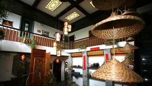 A traditional interior with a central staircase, hanging woven lamps, and decorative elements. - Wuming Inn (Dali City)
