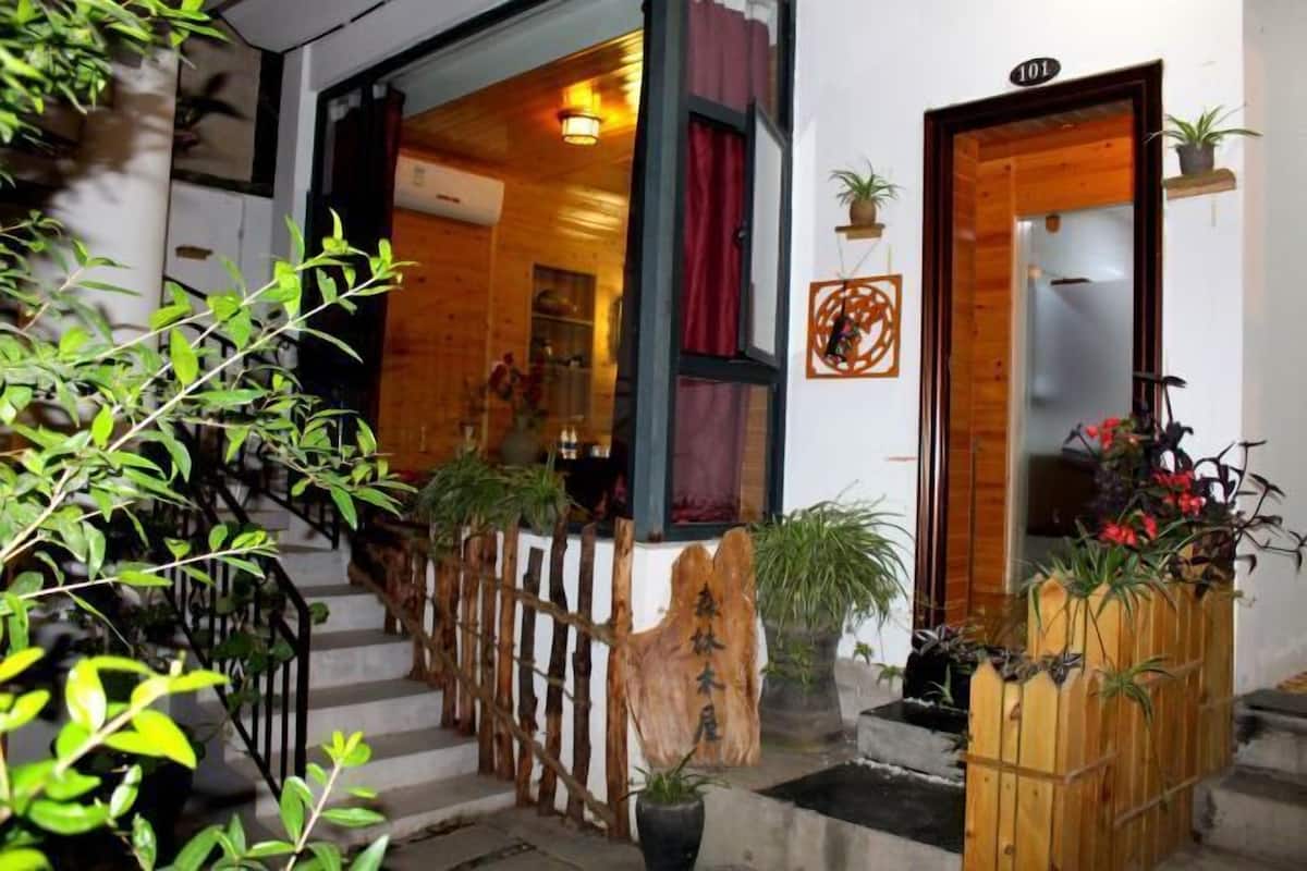Un escalier en bois mène à une pièce dont la porte, également en bois, est marquée du numéro « 101 ».