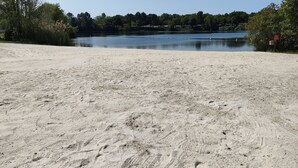 A sandy beach with footprints leading to a calm lake surrounded by trees. - Vacation rental near Royan in a magnificent setting (sainte gemme)