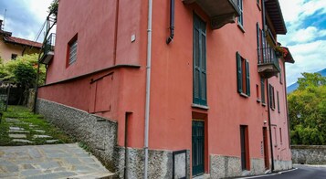 Un edificio rosso con una scalinata in pietra che conduce a una porta.