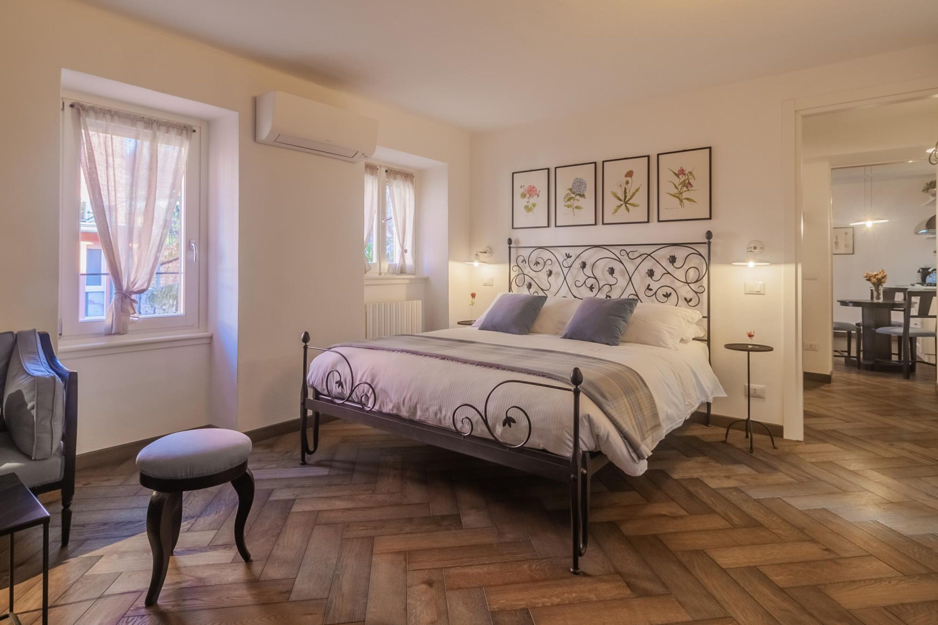 A bedroom with a bed, a chair, a small table, and a radiator.