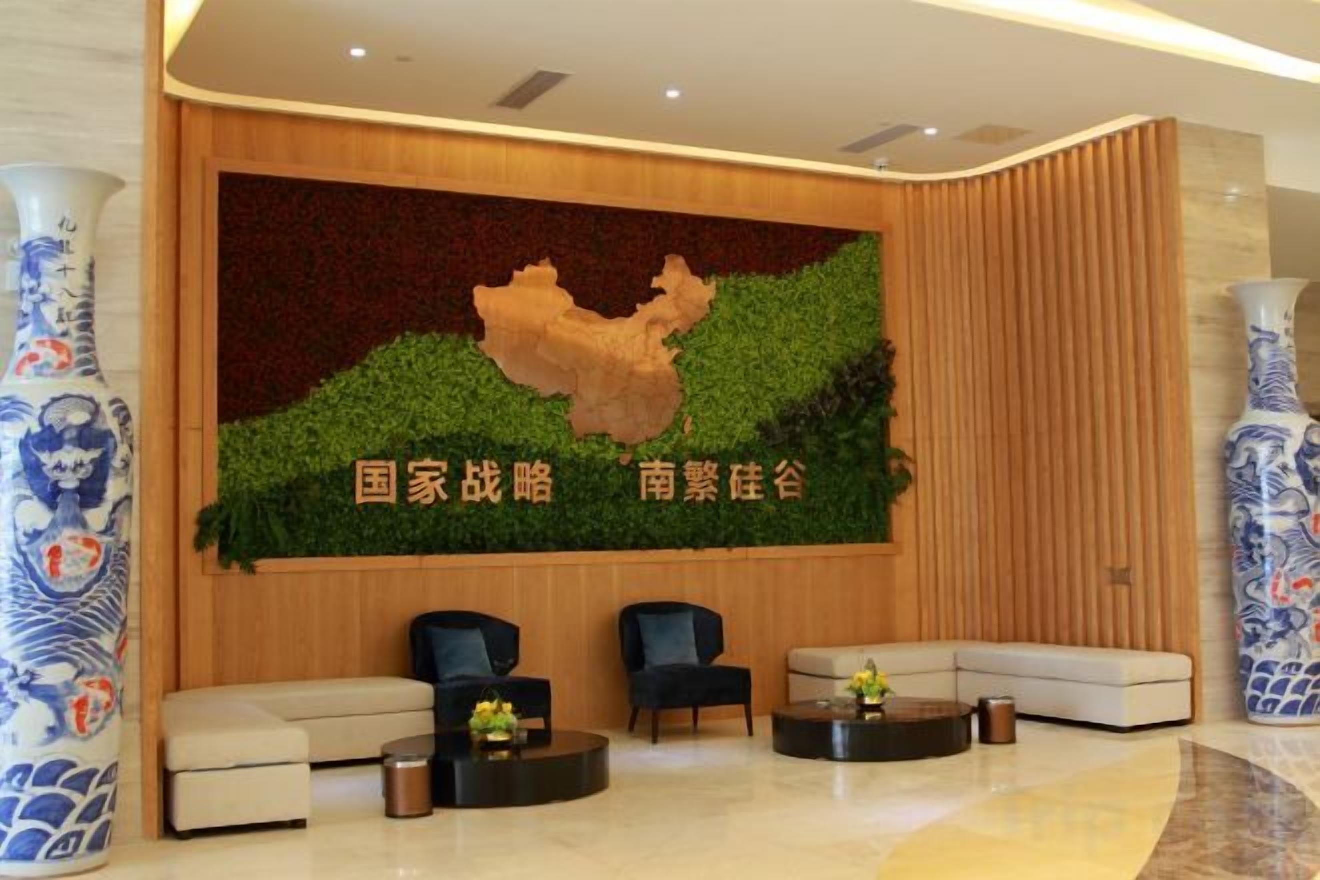 A reception area with a large wall mural, seating arrangements, and decorative vases.