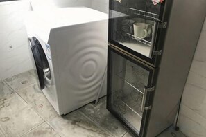 A compact kitchen with a white washing machine and a black refrigerator with a glass door. - Aixi Jialin Hotel(Chongqing Bishan Junhao Central Street Store) (Chongqing)