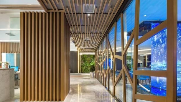 A corridor with a wooden partition, glass walls, and a ceiling with recessed lighting. - Aixi Jialin Hotel(Chongqing Bishan Junhao Central Street Store) (Chongqing)
