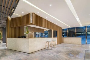 A modern reception area with a marble floor, a wooden reception desk, and a glass partition. - Aixi Jialin Hotel(Chongqing Bishan Junhao Central Street Store) (Chongqing)