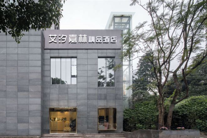 Un bâtiment moderne avec une enseigne indiquant « Hôtel de luxe Wenyi Jiale ».
