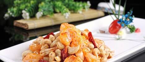A plate of shrimp with peanuts and red chili peppers.
