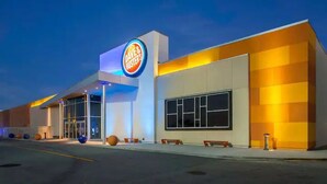 Un bâtiment moderne, avec une enseigne Dave & Buster's, de grandes fenêtres et un toit plat.