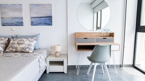 Une chambre à coucher comprenant un lit, une table de chevet, une lampe et un bureau avec une chaise.