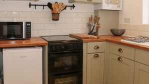 A kitchen with a microwave, stove, oven, and a dishwasher. - Hope Cottage (Thornton-Cleveleys)