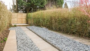 A pathway with gravel and a wooden fence in the background. - Hope Cottage (Thornton-Cleveleys)
