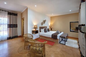 A hotel room with a bed, two bedside tables, a chair, a bench, a mirror, and a window with curtains. - The Nkhosi Livingstone Lodge and Spa (Livingstone)