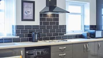 Escritorio, tabla de planchar con plancha y ropa de cama