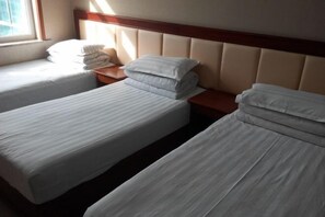 A hotel room with two single beds, a wooden headboard, and a window providing natural light. - Xiangzheng Hotel (Qi County)