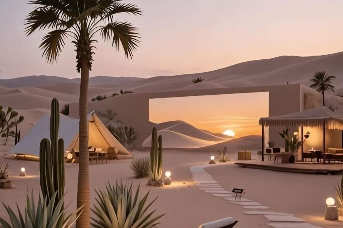 A desert resort with tents, palm trees, and a sunset view.