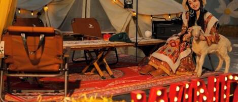 A tent with a laptop, a chair, and a table with a blanket.