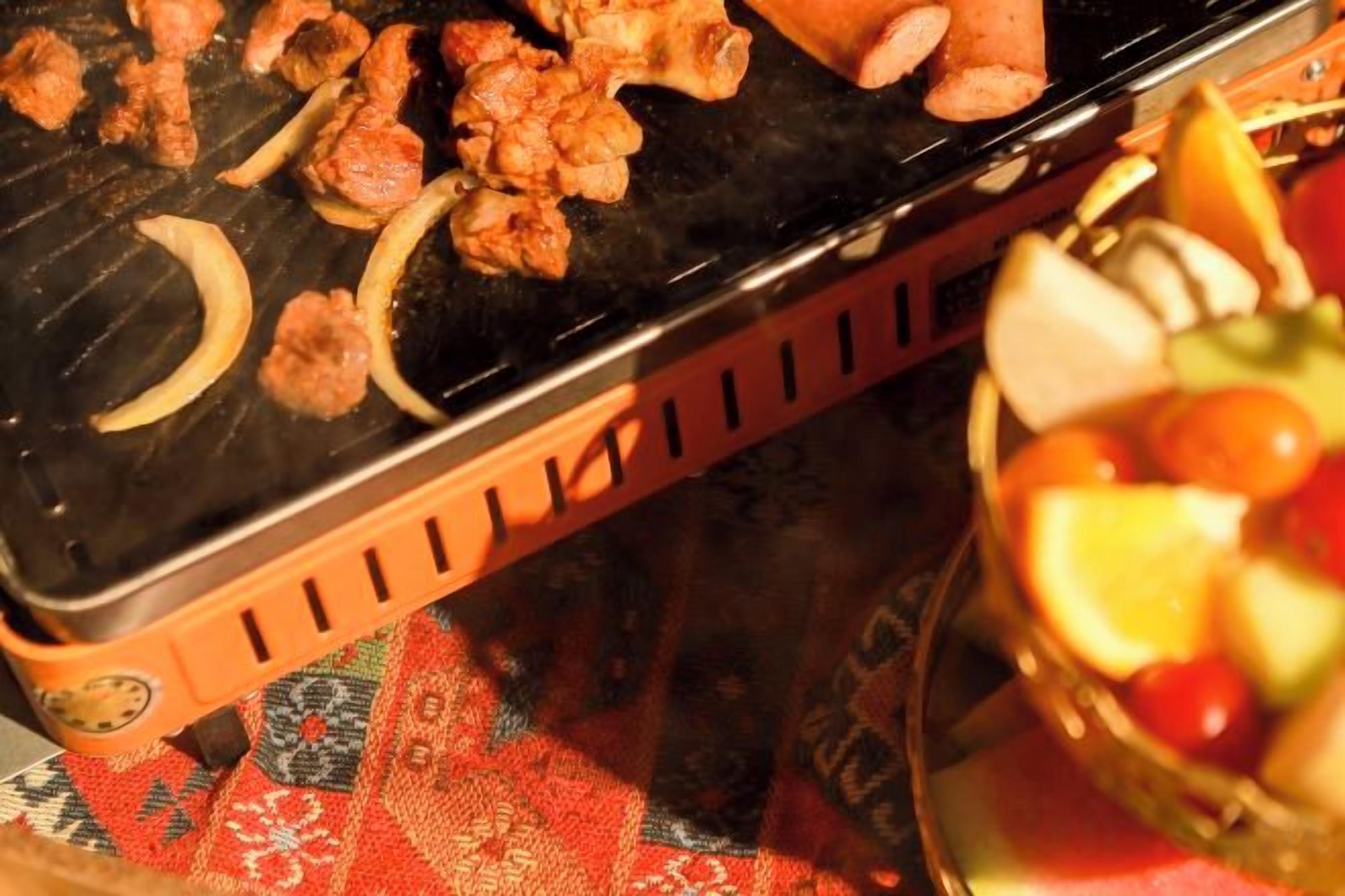 Ein Grill mit Essen und einer Fruchtkorb.