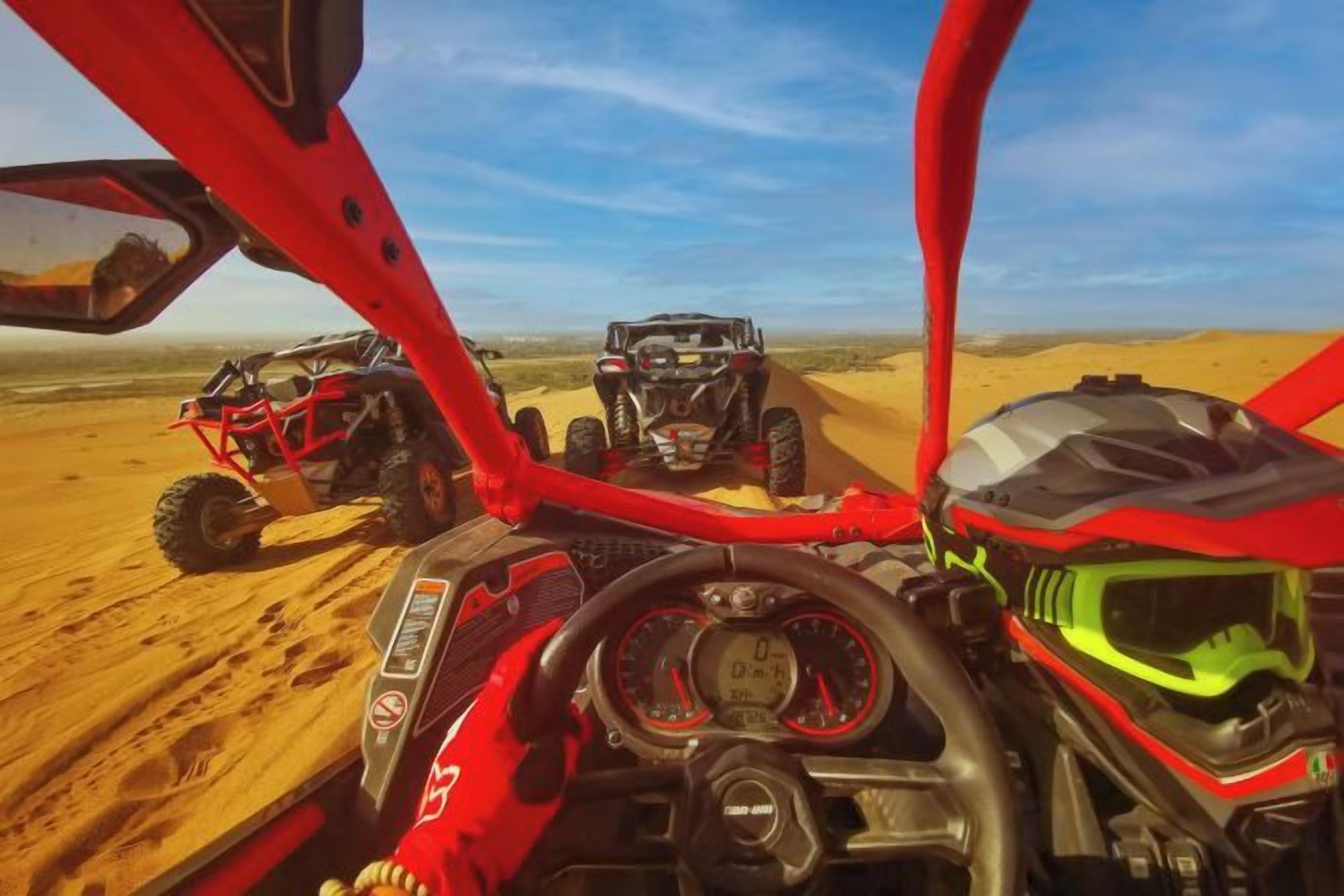 A desert landscape with two off-road vehicles.