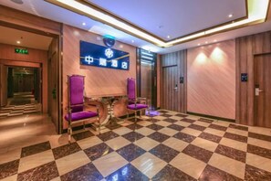 A hotel lobby with a checkered floor, a reception desk, and purple seating. - Yiwang Hotel Selected (Dong'Ou Zhiku, Wenzhou New Town) (Wenzhou)