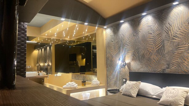 A modern bathroom with a large mirror, dual sinks, and a seating area with a sofa and pillows. - SUITES IN THE HEART OF NAPLES WITHIN WALKING DISTANCE OF MAJOR ATTRACTIONS (Napoli)