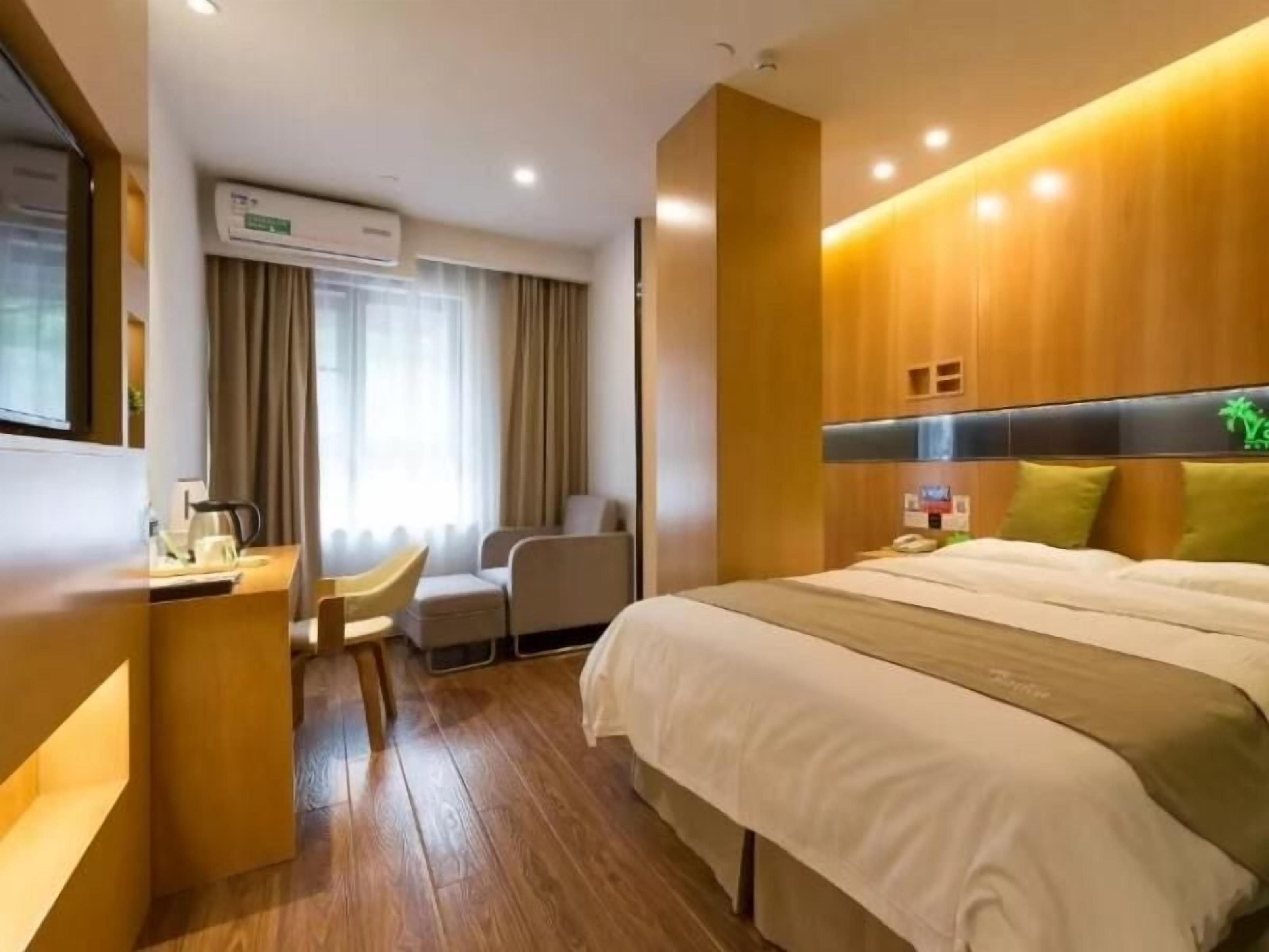 Une chambre d’hôtel équipée d’un lit, d’un bureau, d’une chaise et d’un appareil de climatisation.