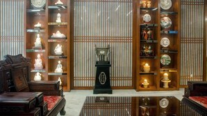 A traditional room with wooden furniture, a tea set, and a decorative stand. - Yabo Hotel (Hengyang)