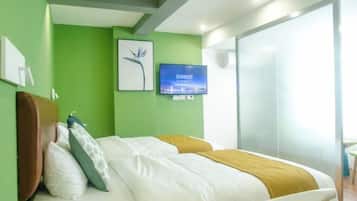 Una habitación de hotel con una cama, televisión, un cuadro en la pared y una ventana.