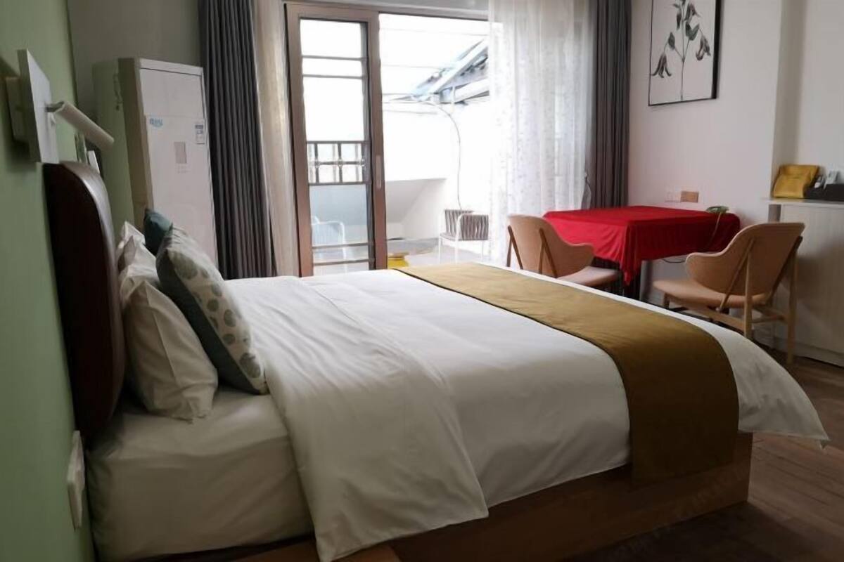 A hotel room with a bed, a desk, and a chair.