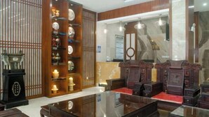 A traditional room with a wooden cabinet displaying various items, a glass-top table, and two wooden chairs. - Yabo Hotel (Hengyang)