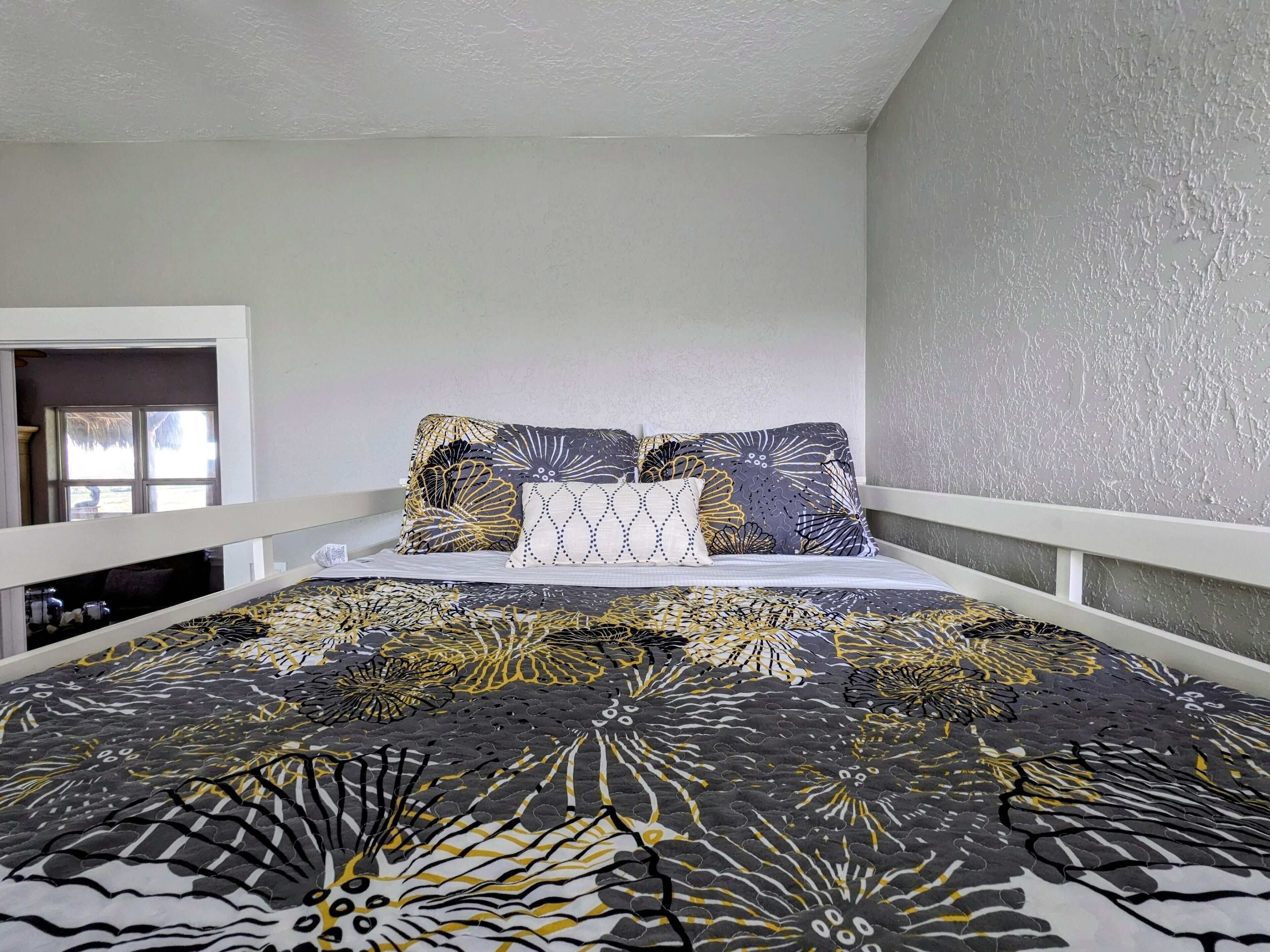 Una camera da letto con un letto, cuscini e una finestra.
