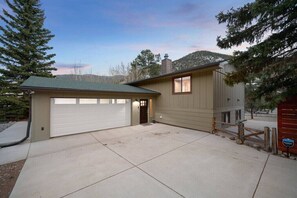 A single-story house with a garage, a small porch, and a wooden fence.