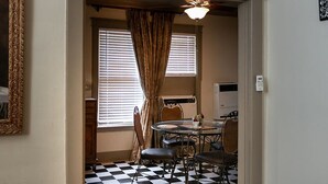 A room with a checkered floor, a dining table with chairs, a ceiling fan, and a window with blinds. - Upper 2 Bedroom Loft Apartment (Memphis)