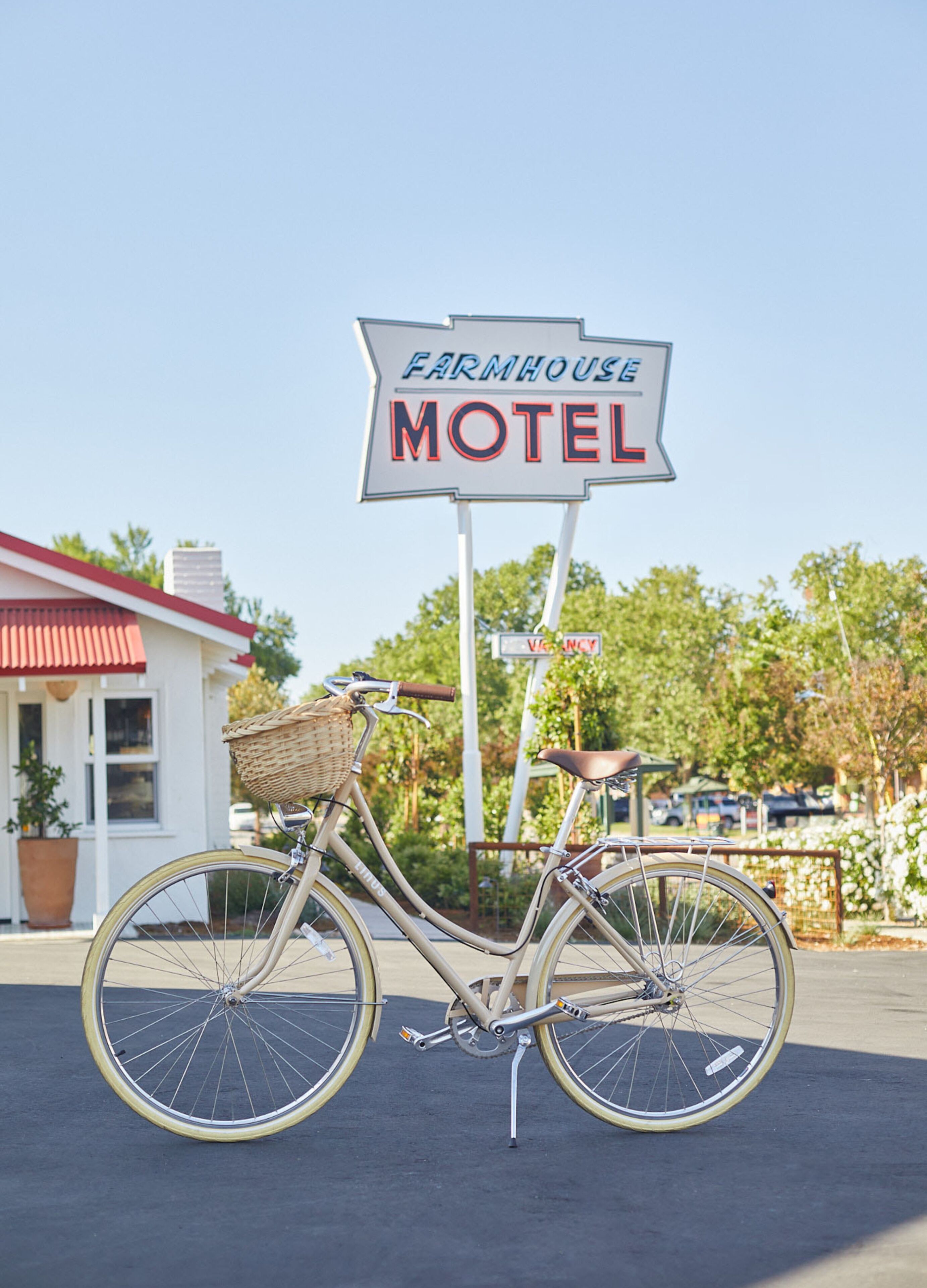 A bicycle parked in front of a sign that reads "Farmhouse Motel".