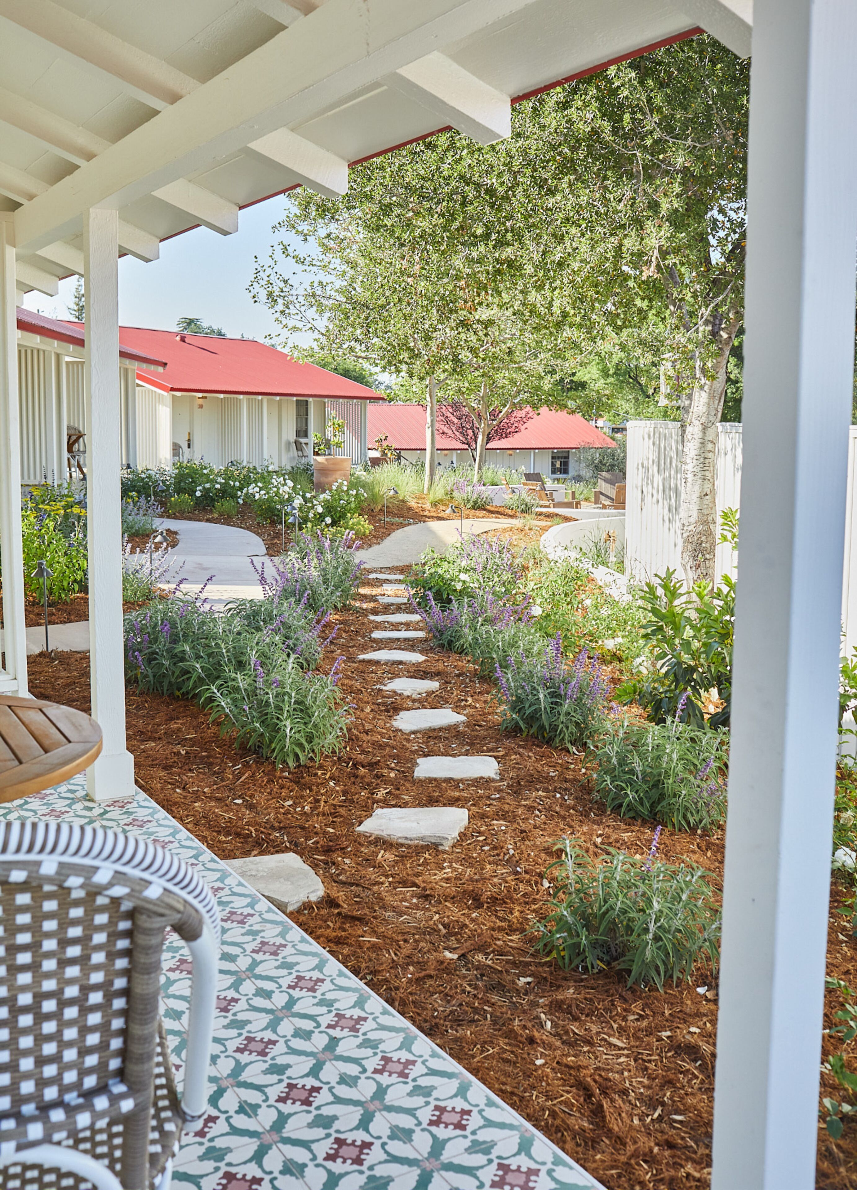 A covered patio area with a stone pathway leading to a seating area.