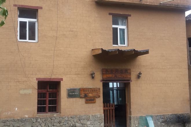 Un edificio de ladrillo con un letrero, una puerta y una ventana.