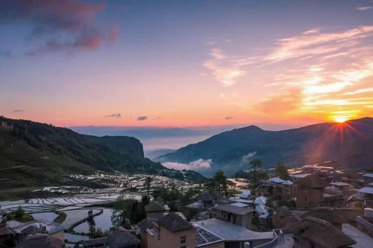 A mountainous landscape with terraced fields and traditional buildings.