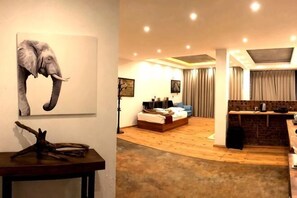 Une chambre d’hôtel comprenant un lit, un bureau, une chaise, un coin repas et une grande fenêtre.