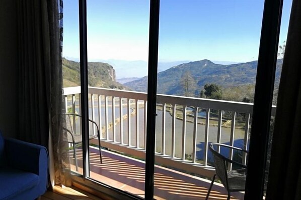 Un balcón con vistas a montañas y una carretera.