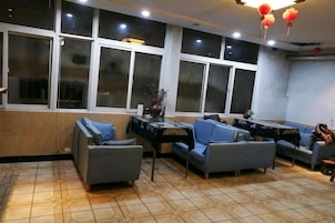 Una habitación con sofá, una mesa y una ventana con persianas.