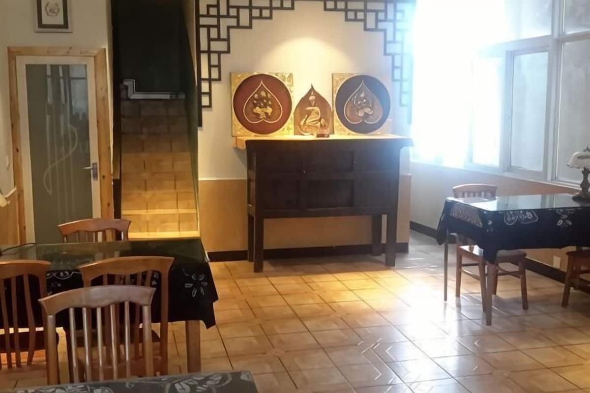 A dining area with a glass table, wooden chairs, a fireplace, and wall art.
