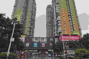 Un edificio de gran altura con varios balcones y una zona comercial en la planta baja.