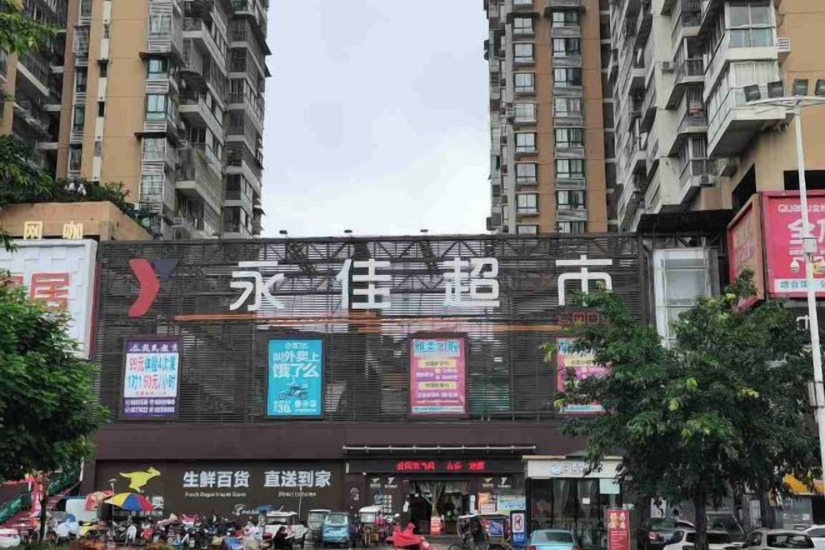 A multi-story building with a large digital billboard displaying various advertisements.