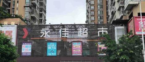 A multi-story building with a large digital billboard displaying various advertisements.