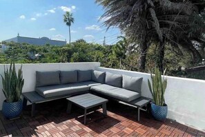 Relax on the patio surrounded by lush greenery and enjoy the serene atmosphere.