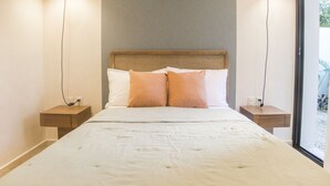 A bedroom with a large bed, two bedside tables, and a window. - Kuxtal Tulum (Tulum)